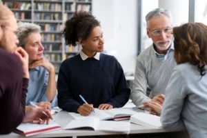 pessoas em volta de uma mesa discutindo plano de acao escolar